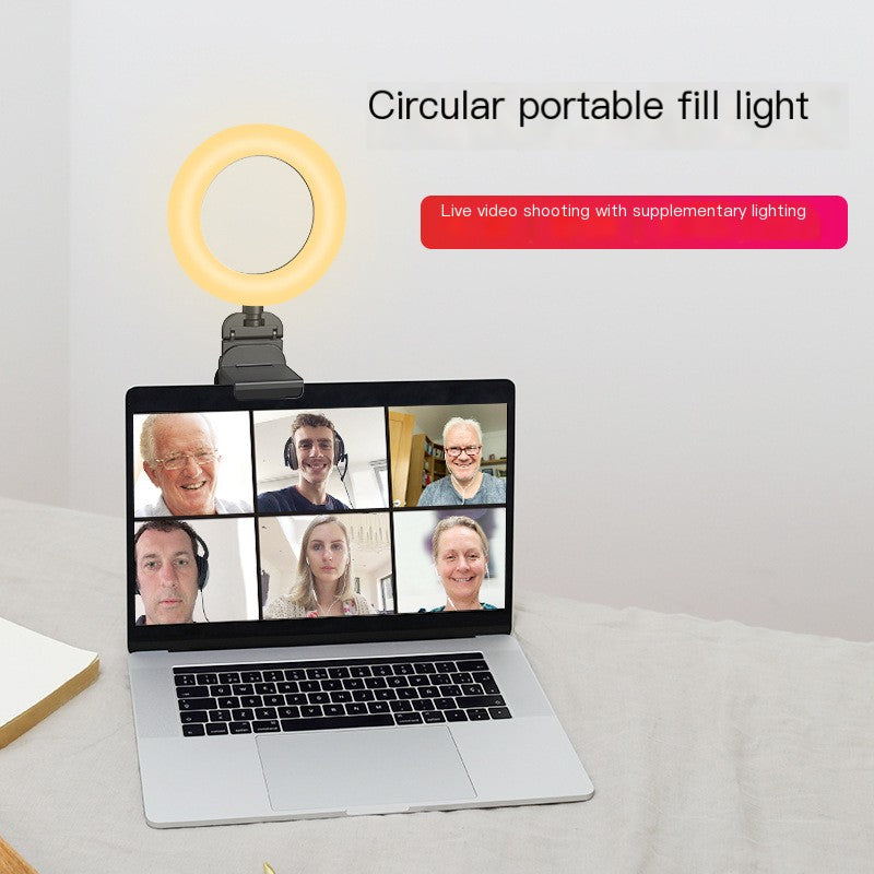 Circular portable fill light on a laptop screen with multiple people on a video call.